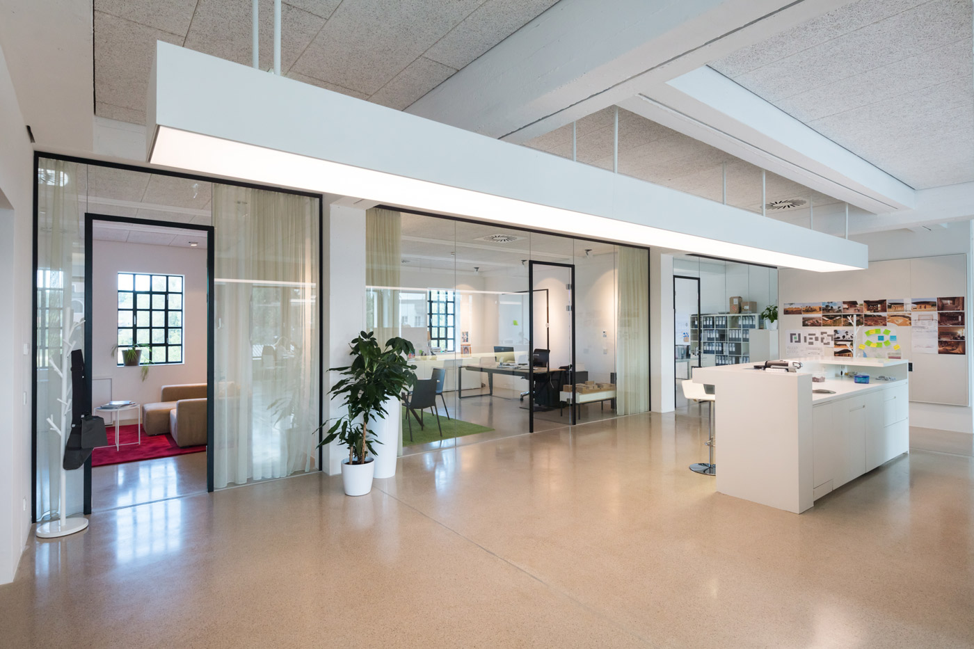 Das Büro von F2 Architekten: offener Raum mit verglasten Besprechungsräumen und Empfangstheke